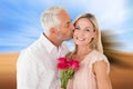 Composite image of affectionate man kissing his wife on the cheek with roses Royalty Free Stock Photo