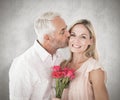 Composite image of affectionate man kissing his wife on the cheek with roses Royalty Free Stock Photo