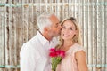 Composite image of affectionate man kissing his wife on the cheek with roses Royalty Free Stock Photo