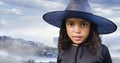 Composite image of african american girl in a witch against winter landscape Royalty Free Stock Photo