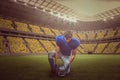 Composite image of american football player looking down while holding helmet with 3d Royalty Free Stock Photo