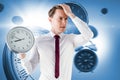 Composite image of anxious businessman holding a clock