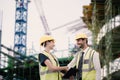 Composite image of architects in reflective clothing doing handshake while holding tablet computer Royalty Free Stock Photo