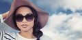 Composite image of attractive asian woman with hat and sunglasses Royalty Free Stock Photo