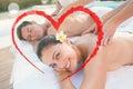 Composite image of attractive couple enjoying couples massage poolside Royalty Free Stock Photo