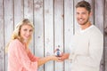 Composite image of attractive couple holding miniature house model Royalty Free Stock Photo