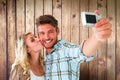 Composite image of attractive couple taking a selfie together Royalty Free Stock Photo