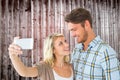 Composite image of attractive couple taking a selfie together Royalty Free Stock Photo