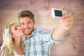 Composite image of attractive couple taking a selfie together Royalty Free Stock Photo