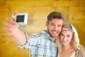 Composite image of attractive couple taking a selfie together Royalty Free Stock Photo