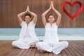 Composite image of attractive couple in white sitting in lotus pose with hands together Royalty Free Stock Photo