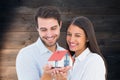 Composite image of attractive young couple holding a model house Royalty Free Stock Photo