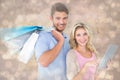 Composite image of attractive young couple holding shopping bags using tablet pc Royalty Free Stock Photo
