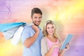 Composite image of attractive young couple holding shopping bags using tablet pc Royalty Free Stock Photo