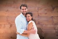 Composite image of attractive young couple hugging and smiling at camera Royalty Free Stock Photo