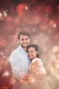 Composite image of attractive young couple hugging and smiling at camera Royalty Free Stock Photo