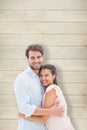Composite image of attractive young couple hugging and smiling at camera Royalty Free Stock Photo