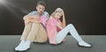 Composite image of attractive young couple sitting holding two halves of broken heart Royalty Free Stock Photo