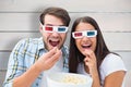 Composite image of attractive young couple watching a 3d movie Royalty Free Stock Photo