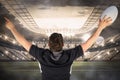 Composite image of back turned rugby player gesturing victory