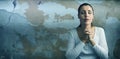 Composite image of beautiful woman praying with joining hands and eyes closed Royalty Free Stock Photo