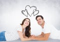 Composite image of black hearts and thoughtful couple lying on floor Royalty Free Stock Photo