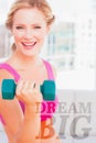 A Composite image of blonde lifting dumbbells and smiling at camera Royalty Free Stock Photo