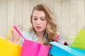 Composite image of blonde woman opening gift bag and looking on it Royalty Free Stock Photo