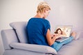 Composite image of blonde woman using her laptop on the couch Royalty Free Stock Photo
