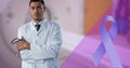 Composite image of blue ribbon and portrait of biracial male doctor standing against mri scanner