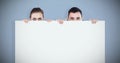 Composite image of business partners hiding behind a sign Royalty Free Stock Photo