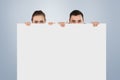 Composite image of business partners hiding behind a sign Royalty Free Stock Photo