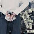 Composite image of businessman in handcuffs holding bribe Royalty Free Stock Photo