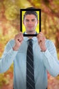 Composite image of businessman holding digital tablet in front of face Royalty Free Stock Photo