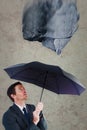 Composite image of businessman sheltering under black umbrella Royalty Free Stock Photo