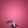 Composite image of businessman sheltering under black umbrella testing Royalty Free Stock Photo