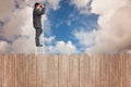 Composite image of businessman standing on ladder using binoculars Royalty Free Stock Photo