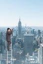 Composite image of businessman standing on ladder using binoculars Royalty Free Stock Photo