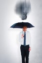 Composite image of businessman standing under black umbrella Royalty Free Stock Photo