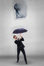 Composite image of businessman standing under black umbrella Royalty Free Stock Photo