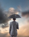 Composite image of businessman standing under umbrella Royalty Free Stock Photo