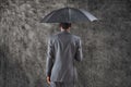 Composite image of businessman standing under umbrella Royalty Free Stock Photo