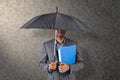 Composite image of businessman standing under umbrella Royalty Free Stock Photo