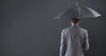 Composite image of businessman standing under umbrella Royalty Free Stock Photo