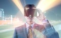 Composite image of businessman in suit using virtual reality headset