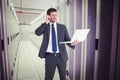 Composite image of businessman talking on phone holding laptop Royalty Free Stock Photo