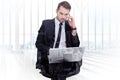 Composite image of businessman using laptop while phoning Royalty Free Stock Photo
