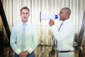 Composite image of businessman yelling with a megaphone at his colleague Royalty Free Stock Photo