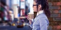 Composite image of businesswoman holding disposable cup and looking at wall with notes Royalty Free Stock Photo