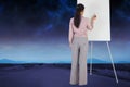 Composite image of businesswoman painting on an easel